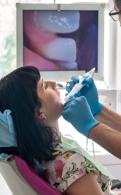 dentist using intraoral camera on patient's teeth